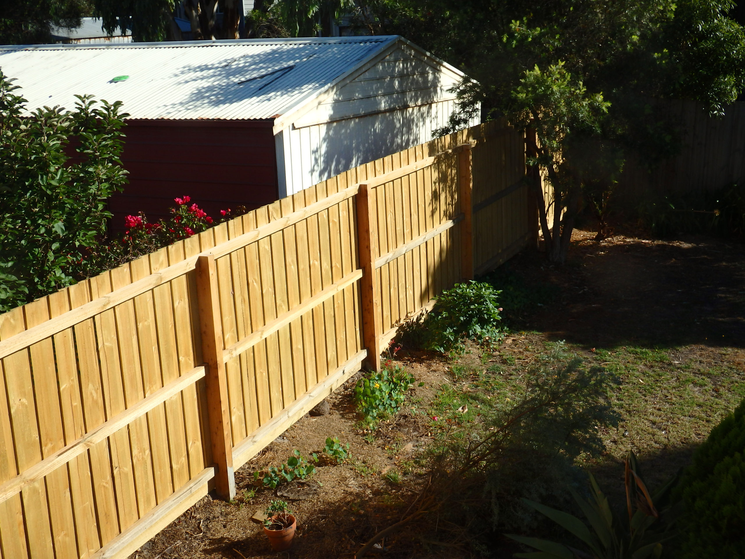 New,Wooden,Fence,Between,Houses,On,Morning,Sunshine